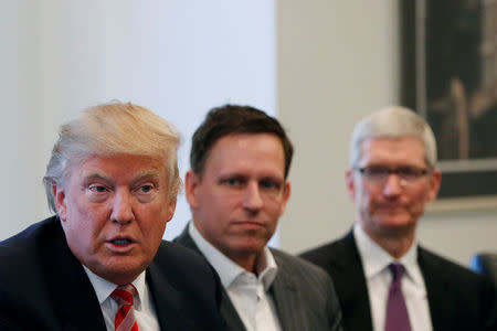 U.S. President-elect Donald Trump speaks as PayPal co-founder and Facebook board member Peter Thiel (C) and Apple Inc CEO Tim Cook look on during a meeting with technology leaders at Trump Tower in New York U.S., December 14, 2016. REUTERS/Shannon Stapleton