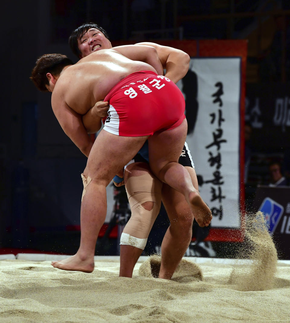 In this Nov. 26, 2017 photo, ssireum wrestlers compete during the Korea Open Ssireum Festival in Naju, South Korea. South Korean culture officials on Monday, Nov. 26, 2018, said a UNESCO committee is set to determine whether to add the Korean wrestling to its list of "Intangible Cultural Heritage of Humanity" this week.(Ryu Hyung-geun/Newsis via AP)