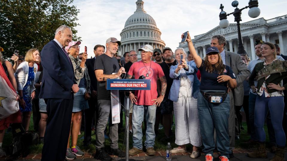 Comedian and activist Jon Stewart and activist John Feal speak during a news conference with veterans and their families after the Senate passed the PACT Act August 2, 2022 in Washington, DC. Demonstrators from veterans-rights groups including the Wounded Warrior Project, Burn Pit 360 and the American Legion, have stood outside the Capitol Building in protest calling on the U.S. Senate to pass the PACT Act, a bill to expand health care benefits for veterans exposed to toxic burn pits.