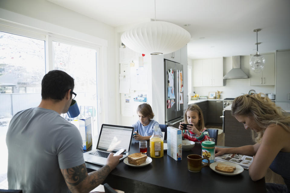 A file picture shows a disengaged family with kids on devices, a father on a laptop and a mum reading a magazine. Source: Getty, file. 