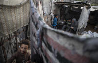 A Palestinian family prepares tea in their house in a slum on the outskirts of Khan Younis Refugee Camp, in the southern Gaza Strip, Wednesday, Nov. 25, 2020. Israel's blockade of the Hamas-ruled Gaza Strip has cost the seaside territory as much as $16.7 billion in economic losses and caused its poverty and unemployment rates to skyrocket, a U.N. report said Wednesday, as it called on Israel to lift the 13-year closure. (AP Photo/Khalil Hamra)