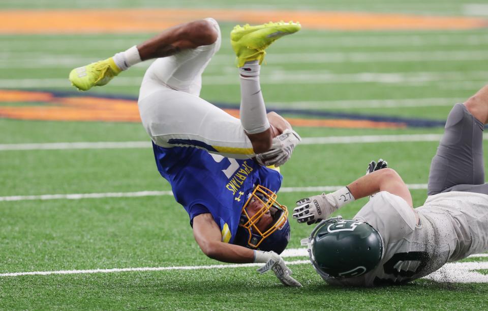 Maine-Endwell Donavin Hamer (5) gets tackled by Pleasantville's Daniel Picard (10) during the Class B state football championship game in the Carrier Dome at Syracuse University. Maine-Endwell won the game 21-12.