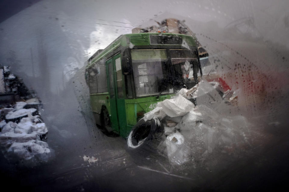 A barricade made of trams, buses and sand bags is seen through the window of car in the northern part of Kyiv, on Tuesday, March 1, 2022. (AP Photo/Ricard Garcia Vilanova)