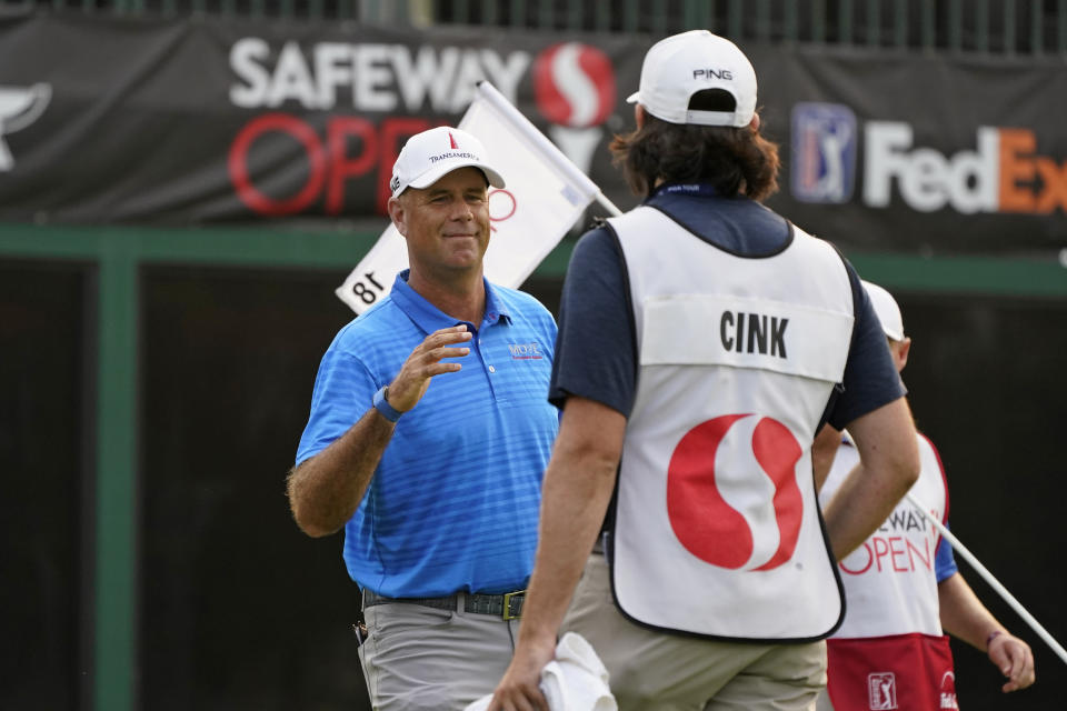 Stewart Cink greets his caddie and son, Reagan Cink, after making a birdie on the 18th green of the Silverado Resort North Course during the final round of the Safeway Open PGA golf tournament Sunday, Sept. 13, 2020, in Napa, Calif. Cink won the tournament after shooting a 7-under-par 65 to finish at total 21-under-par. (AP Photo/Eric Risberg)