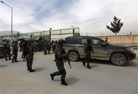 Afghan policemen secure the area outside Cure Hospital after three foreigners were killed in Kabul April 24, 2014. REUTERS/Mohammad Ismail