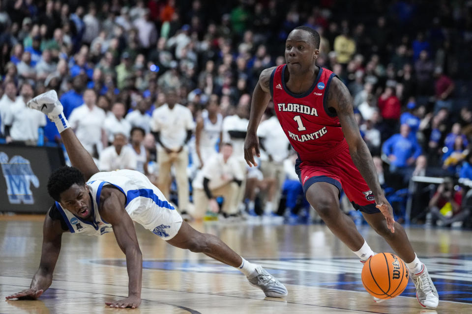 Florida Atlantic guard Johnell Davis (1) drives past Memphis guard Elijah McCadden (0) in the second half of a first-round college basketball game in the men's NCAA Tournament in Columbus, Ohio, Friday, March 17, 2023. Florida Atlantic defeated Memphis 66-65. (AP Photo/Michael Conroy)