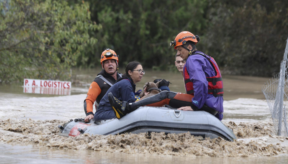 Firefighters with a rubber dinghy evacuee people and dogs from a flooded building in Larissa, central Greece, Wednesday, Sept. 6, 2023. Fierce rainstorms are battering neighboring Greece, Turkey and Bulgaria, causing several deaths. (AP Photo/Vaggelis Kousioras)