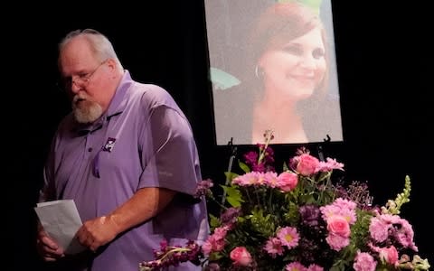 Heather Heyer's father Mark passes picture of his daughter after addressing memorial service  - Credit: Reuters