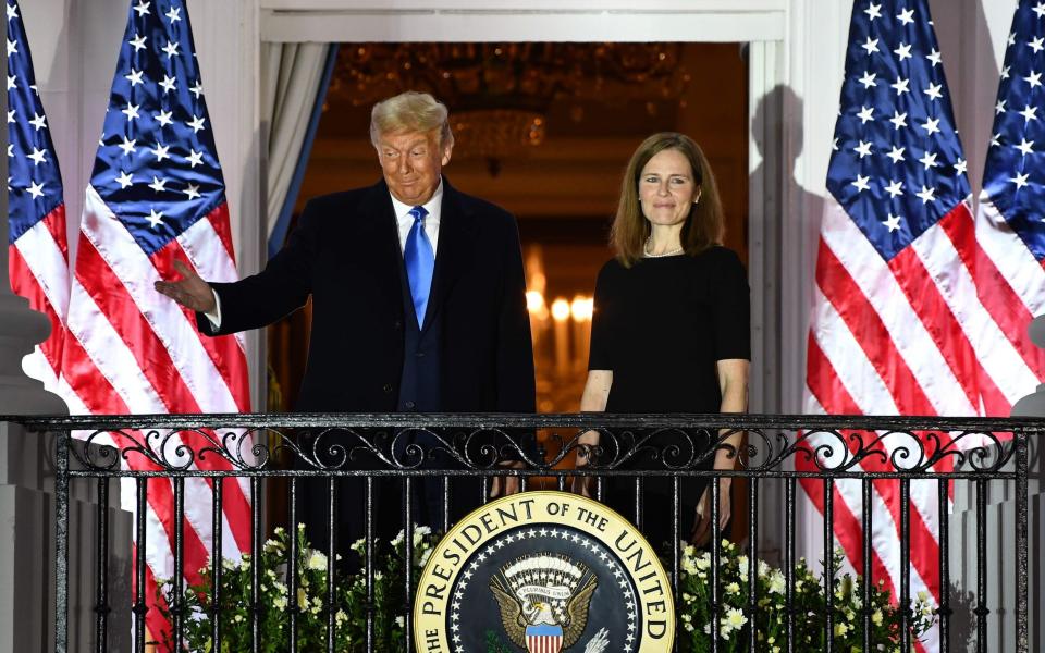 US President Donald Trump gestures next to Judge Amy Coney Barrett  - AFP