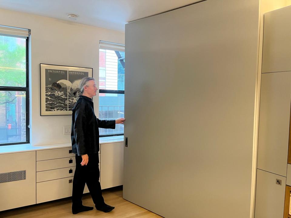 Robert Garneau closes the gray wall back into place. 