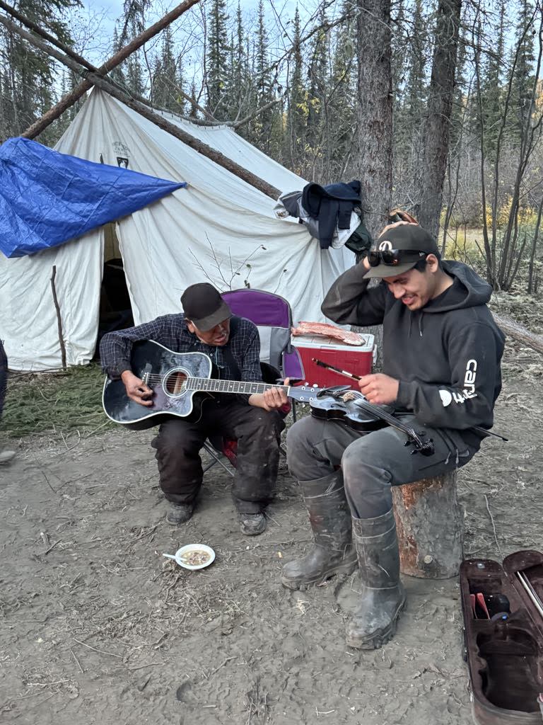 A group of people in Fort McPherson, N.W.T., including youth and elders, travelled up the Peel River in September 2024 for a moose hunting camp. They brought along some musical instruments. 