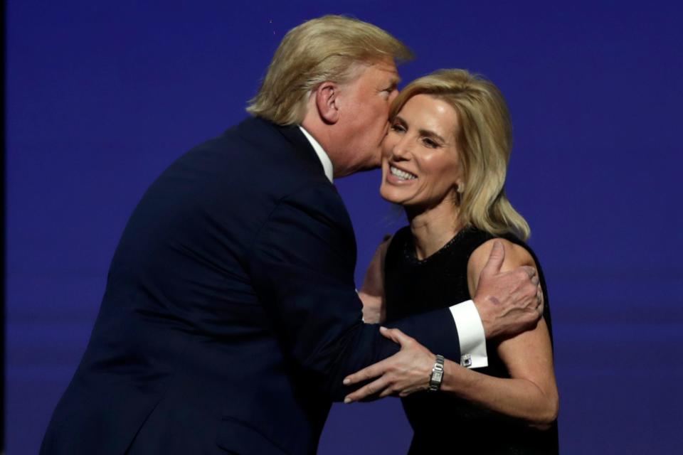 President Donald Trump gives Laura Ingraham a kiss after inviting her on stage during the Turning Point USA Student Action Summit at the Palm Beach County Convention Center, Saturday, Dec. 21, 2019, in West Palm Beach, Fla.