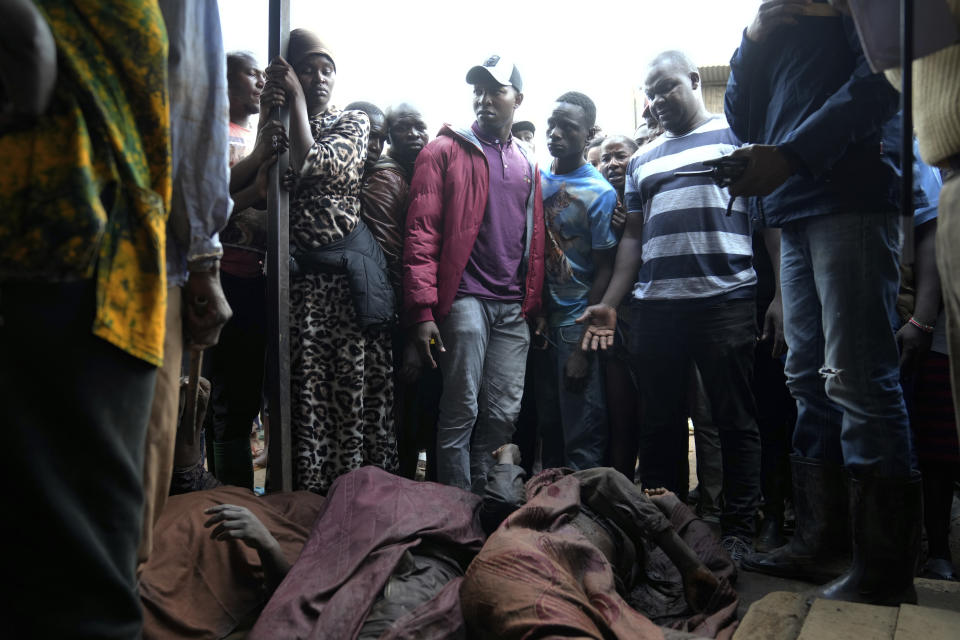 Residents gather around the covered body of a women retrieved from a house, after heavy rain in the Mathare slum of Nairobi, Kenya, Wednesday, April 24, 2024. Heavy rains pounding different parts of Kenya have led to dozens of deaths and the displacement of tens of thousands of people, according to the U.N., citing the Red Cross. (AP Photo/Brian Inganga))