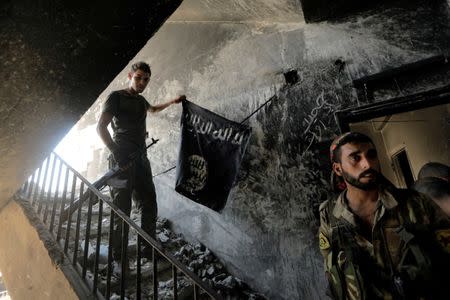 A member of the Syrian Democratic Forces calls his comrades during the fighting with Islamic State fighters in Raqqa, Syria August 14, 2017. REUTERS/Zohra Bensemra