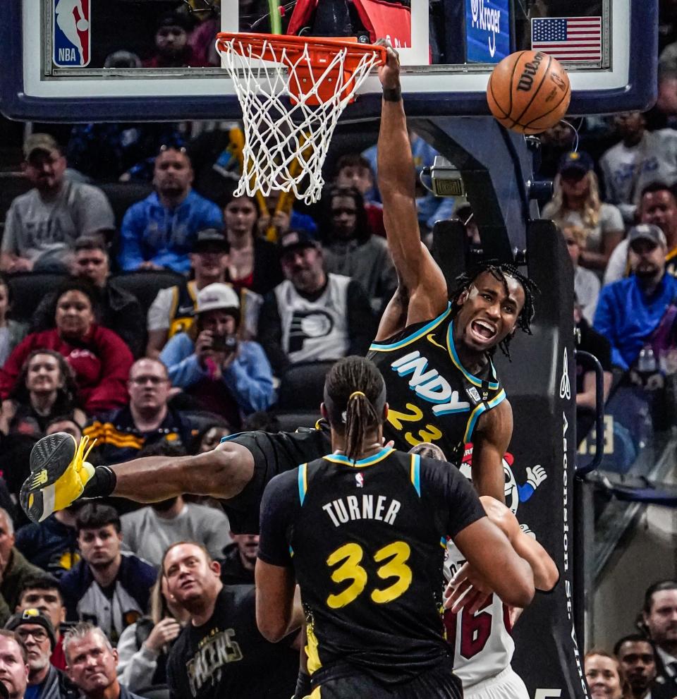 Indiana Pacers forward Aaron Nesmith (23) hangs on the rim after a play was stopped during a game between the Indiana Pacers and the Miami Heat on Sunday, April 7, 2024, at Gainbridge Fieldhouse in Indianapolis.