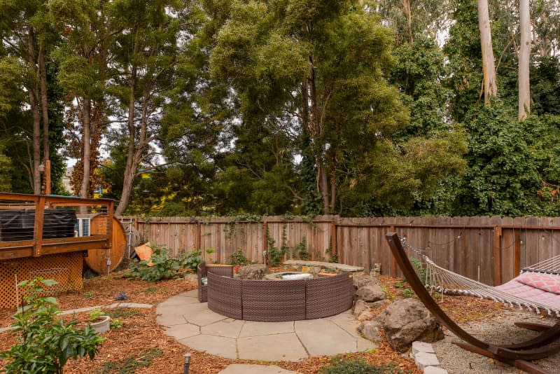 Outdoor seating area around fire pit in shared home.