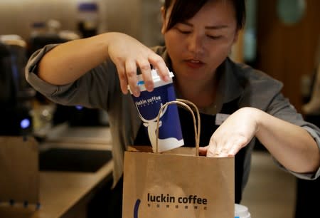FILE PHOTO: A barista packs a coffee for online sales at a Luckin Coffee store in Beijing, China