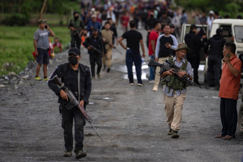 Dateibild: Bewaffnete Mitglieder der Meitei-Gemeinschaft tragen automatische Waffen, während sie auf einen Hügel in Manipur (AP) zustürmen.