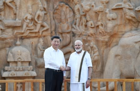 China's President Xi Jinping shakes hand with India's Prime Minister Narendra Modi during their visit to Arjuna's Penance in Mamallapuram