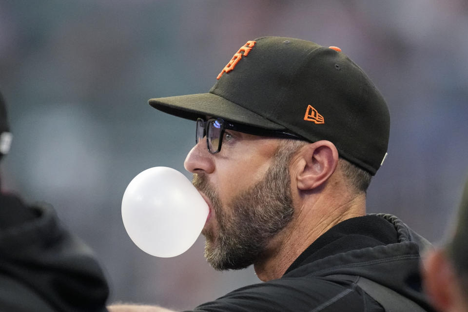 San Francisco Giants manager Gabe Kapler blows a bubble as he watches from the dugout during the team's baseball game against the Atlanta Braves on Saturday, Aug. 19, 2023, in Atlanta. (AP Photo/John Bazemore)