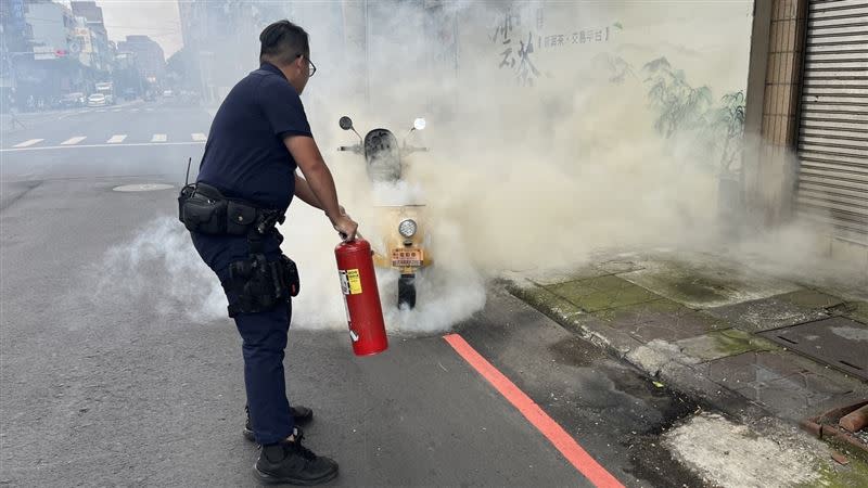 警方噴完整罐乾粉滅火器還是無法阻止冒煙。（圖／翻攝畫面）