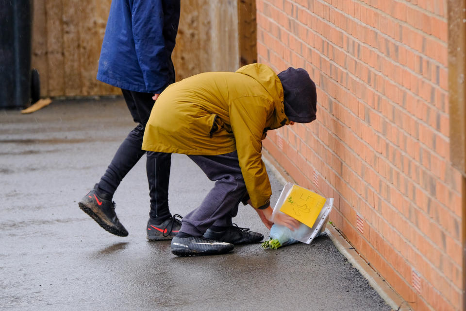 People laying flowers outside the home. (SWNS)