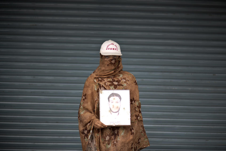 Sameena Rudni, 20, poses for a portrait holding a photograph of her brother Mushtaq, who went missing on March 27, 2009, while she and other relatives take a break from a long march protest, in Rawalpindi, Pakistan, Friday, Feb. 28, 2014. She is part of a group of activists from the impoverished southwestern province of Baluchistan who walked roughly 3,000 kilometers (1,860 miles) to the capital of Islamabad to draw attention to alleged abductions of their loved ones by the Pakistani government. (AP Photo/Muhammed Muheisen)