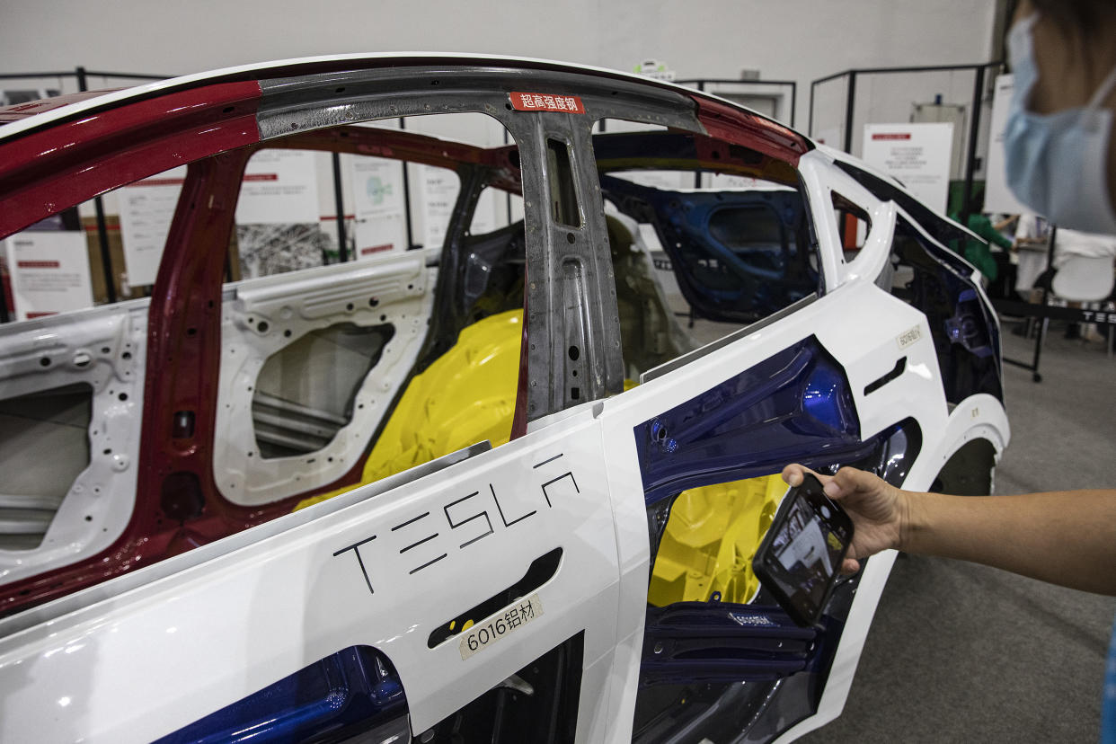 Visitors look at a Tesla model during the 5th China International Industrial Design Expo in Wuhan International Expo Center on August 5,2022 in Wuhan, Hubei Province, China. (Photo by Getty Images)