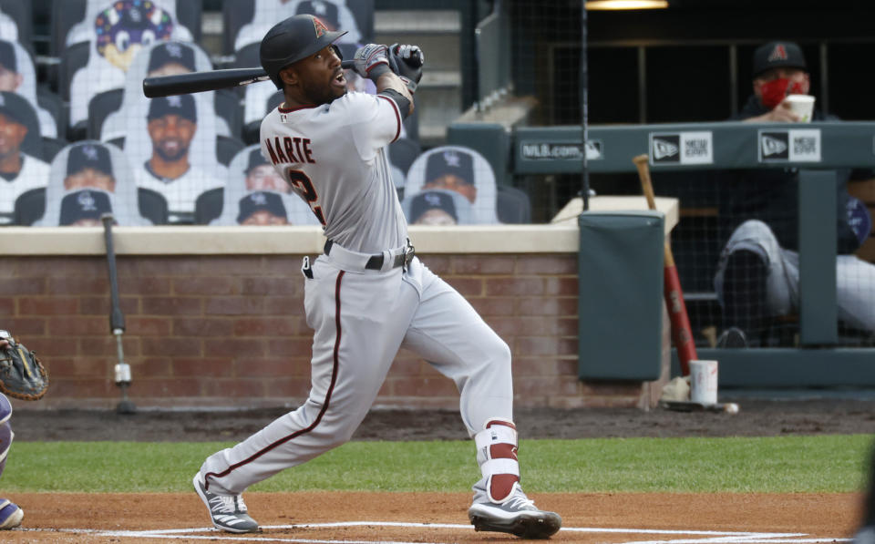 Arizona Diamondbacks' Starling Marte watches his sacrifice fly off Colorado Rockies starting pitcher Jon Gray during the first inning of a baseball game Monday, Aug. 10, 2020, in Denver. (AP Photo/David Zalubowski)