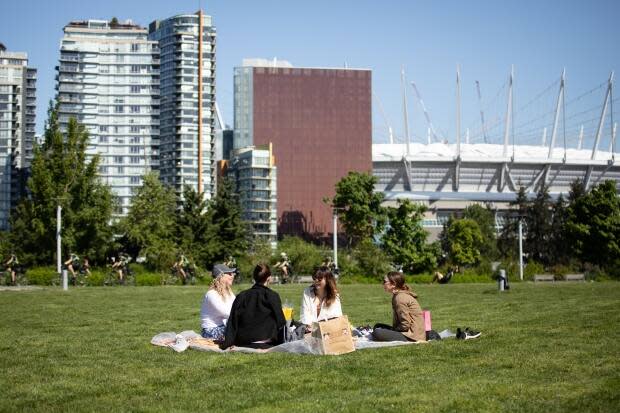 Group of friends meet on a blanket in the sun at Hinge Park in Vancouver, B.C., on Friday, May 14, 2021.