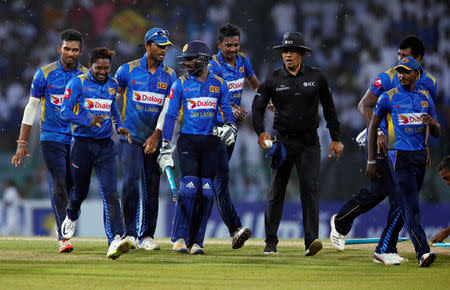 Cricket - Sri Lanka v England- Fifth One-Day International - Colombo, Sri Lanka - October 23, 2018. Sri Lanka's captain (3rd L) and his teammates walk off the field as the match was stopped due to rain. REUTERS/Dinuka Liyanawatte