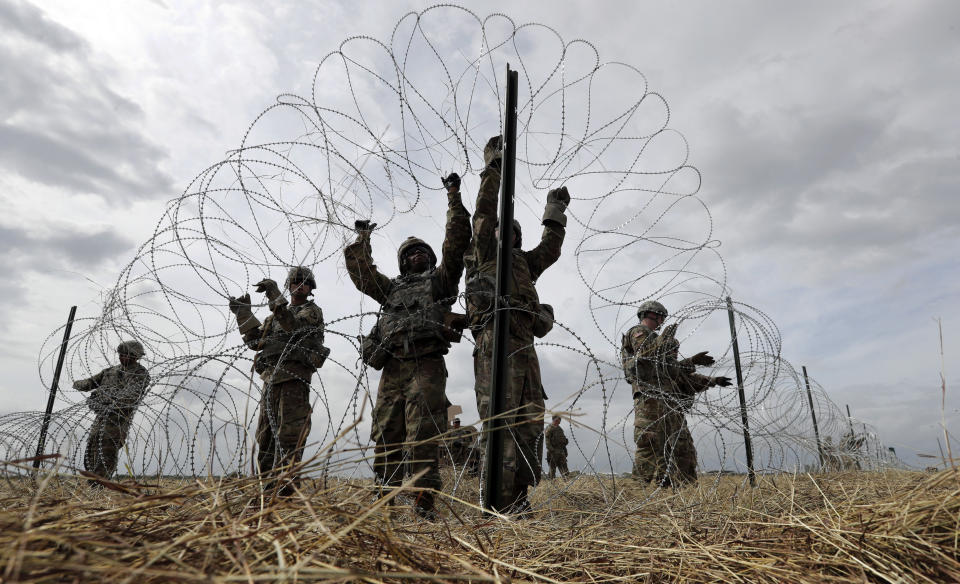 Members of a U.S Army engineering brigade place concertina wire around an encampment for troops, and personnel from the Department of Defense and U.S. Customs and Border Protection near the U.S.-Mexico International bridge, Sunday, Nov. 4, 2018, in Donna, Texas. (AP Photo/Eric Gay)