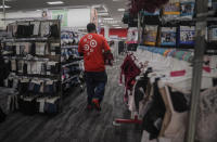 An associate stock shelves in the women's wear department at a Target store, Tuesday Oct. 20, 2020, in New York. The coronavirus pandemic is transforming holiday hiring this year, with companies starting hiring earlier and offering extra safety protocols. Target said it expects to hire more than 100,000 people for the holiday season. (AP Photo/Bebeto Matthews)