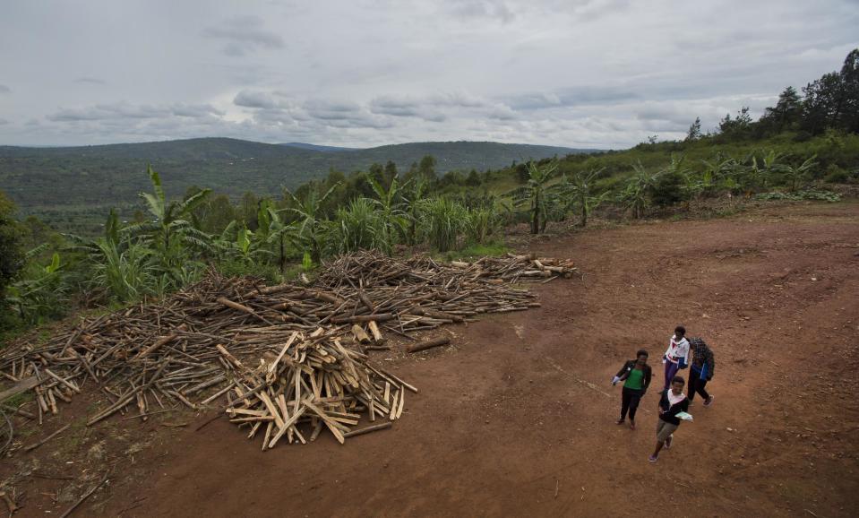 In this photo taken Monday, March 24, 2014, a group of Rwandan students return back to their dormitories after having lunch in the cafeteria at the Agahozo-Shalom Youth Village near Rwamagana, in Rwanda. Most of the kids in a Rwandan school set amid the lush green, rolling hills of eastern Rwanda don’t identify themselves as Hutu or Tutsi. That’s a positive sign for Rwanda, which is now observing the 20th anniversary of its genocide, a three-month killing spree that, according to the official Rwandan count, left more than 1 million people dead, most of them Tutsis killed by Hutus. The teenagers attending the Agahozo-Shalom Youth Village, a school with dorms that creates tight-knit student families, say the ethnic slaughter that their parents or grandparents were a part of either as victims or perpetrators won’t be repeated. The school director echoes the sentiment. (AP Photo/Ben Curtis)