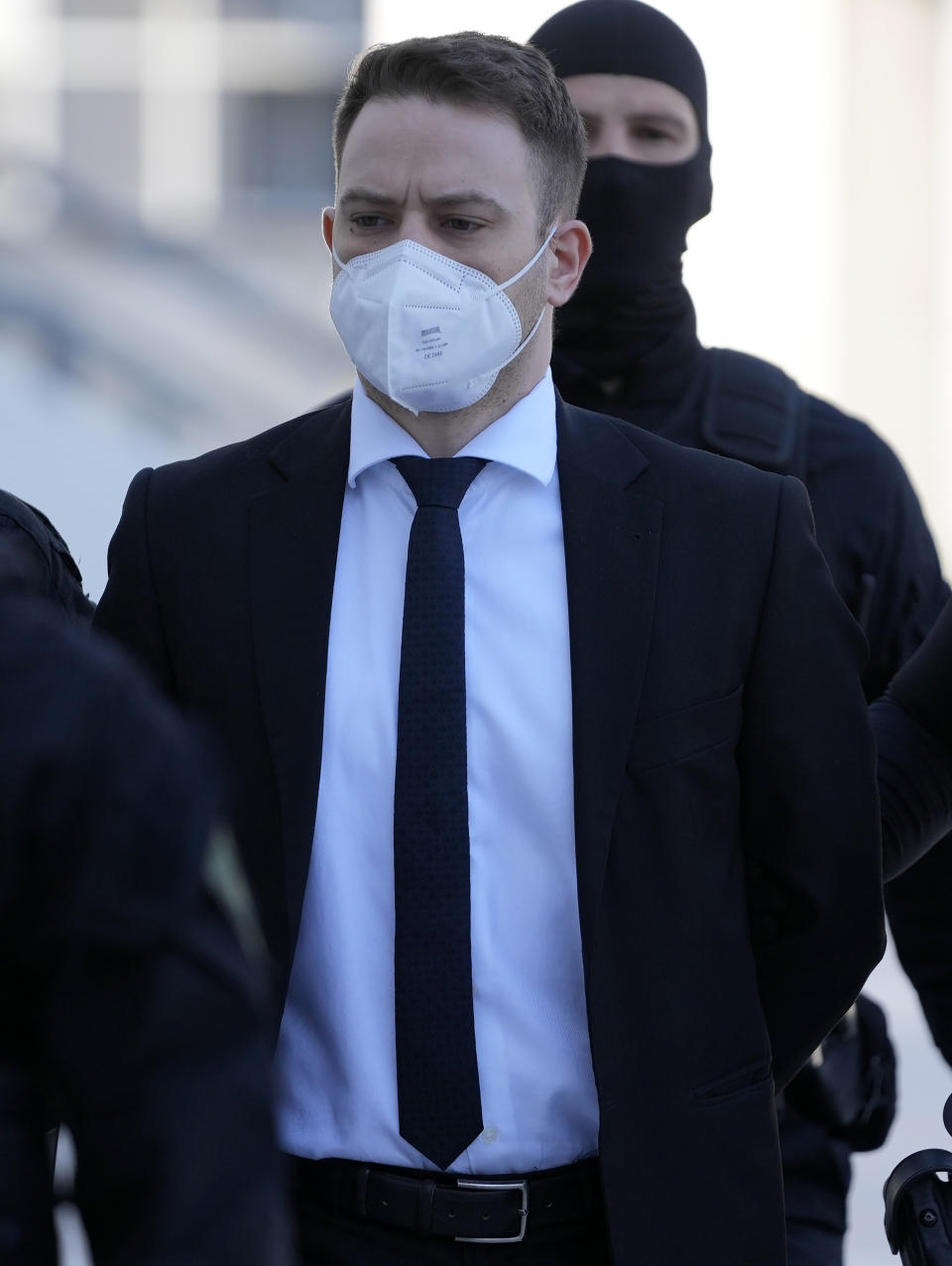 Babis Anagnostopoulos, a Greek pilot and flight instructor, escorted by policemen arrives at a court in Athens, Greece, Monday, May 16, 2022. A verdict is expected Monday in the case of the helicopter pilot who confessed to murdering his young British-Greek wife Caroline Crouch and faking a robbery to mislead police in May 2021. (AP Photo/Thanassis Stavrakis)