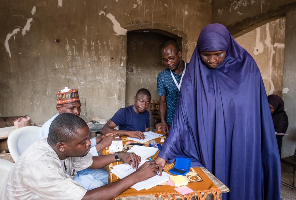 &nbsp;A displaced woman collects her e-voucher from a Mercy Corps team member, during a distribution in a neighborhood in Biu, Nigeria. The vouchers are worth 17,000 Naira/month (for eight months).