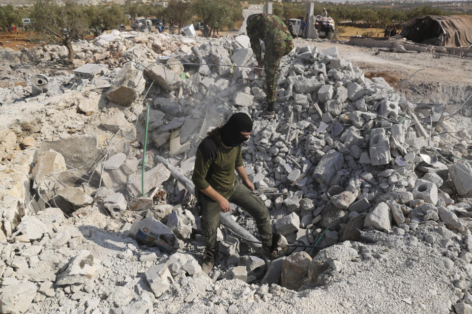 People look at a destroyed houses near the village of Barisha, in Idlib province, Syria, Sunday, Oct. 27, 2019, after an operation by the U.S. military which targeted Abu Bakr al-Baghdadi, the shadowy leader of the Islamic State group. President Donald Trump says Abu Bakr al-Baghdadi is dead after a U.S. military operation in Syria targeted the Islamic State group leader. (AP Photo/Ghaith Alsayed)