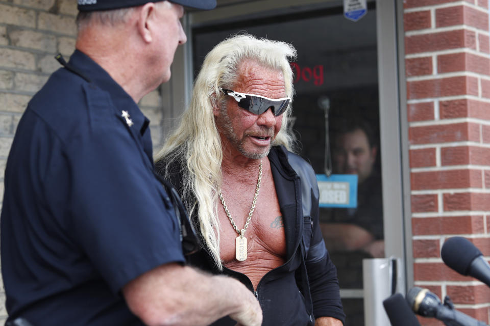 Duane "Dog the Bounty Hunter" Chapman, right greets John Mackey, chief of police of Edgewater, Colo., during a news conference outside Chapman's storefront that was burglarized Friday, Aug. 2, 2019, in Edgewater, Colo. Police in Colorado said Friday they are investigating a reported burglary of a business owned by "Dog the Bounty Hunter" reality TV star Duane "Dog" Chapman.(AP Photo/David Zalubowski)
