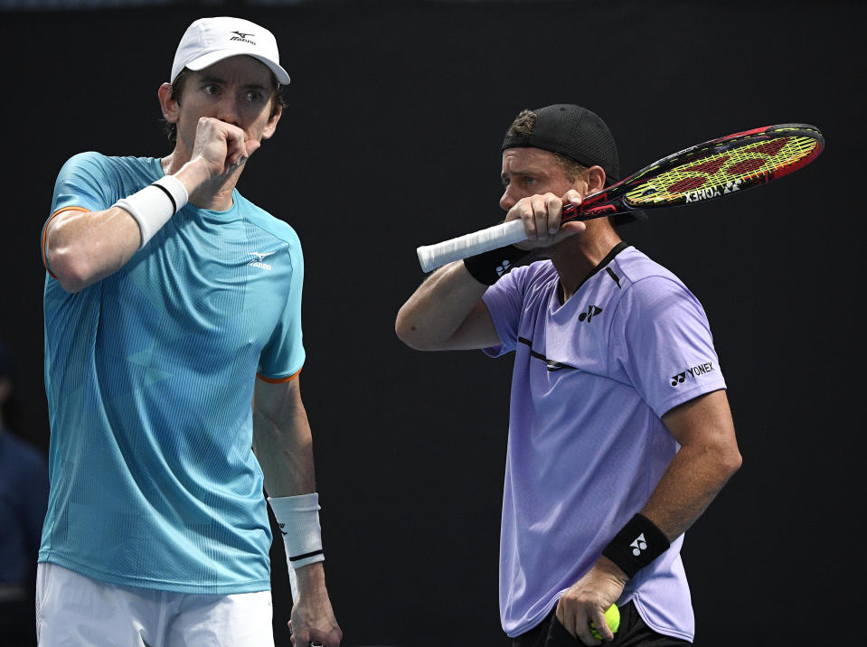 Australia's Lleyton Hewitt talks with compatriot John-Patrick Smith, left, during their first round doubles match against New Zealand's Marcus Daniels and Wesly Koolhof of the Netherlands at the Australian Open tennis championships in Melbourne, Australia, Thursday, Jan. 17, 2019. (AP Photo/Andy Brownbill)