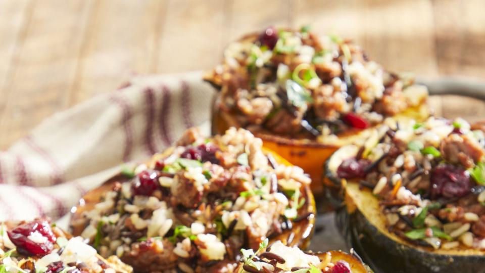 sausage and wild rice stuffed acorn squash on a metal serving tray