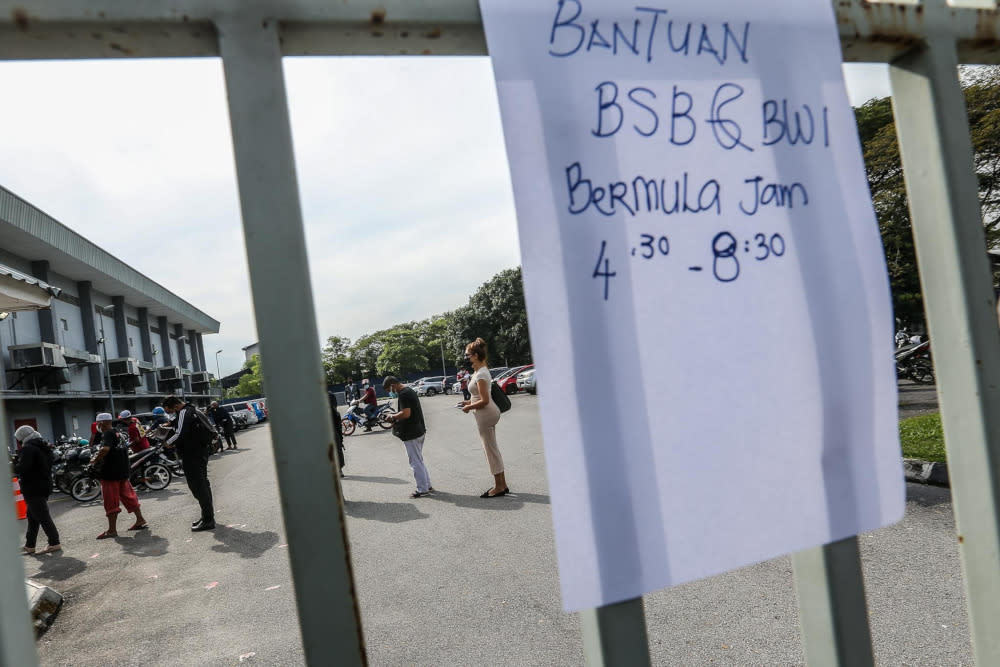 Flood victims queuing up to fill in the application form for Bantuan Wang Ihsan (BWI) and Bantuan Selangor Bangkit (BSB) at Dewan Kenanga Section 28 in Shah Alam, January 11, 2022.  — Picture by Hari Anggara