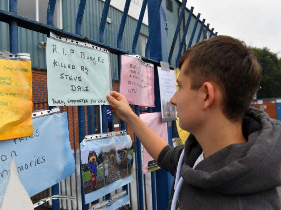 Fans left messages on the Gigg Lane gates as talks began on how to restart the club (PA)