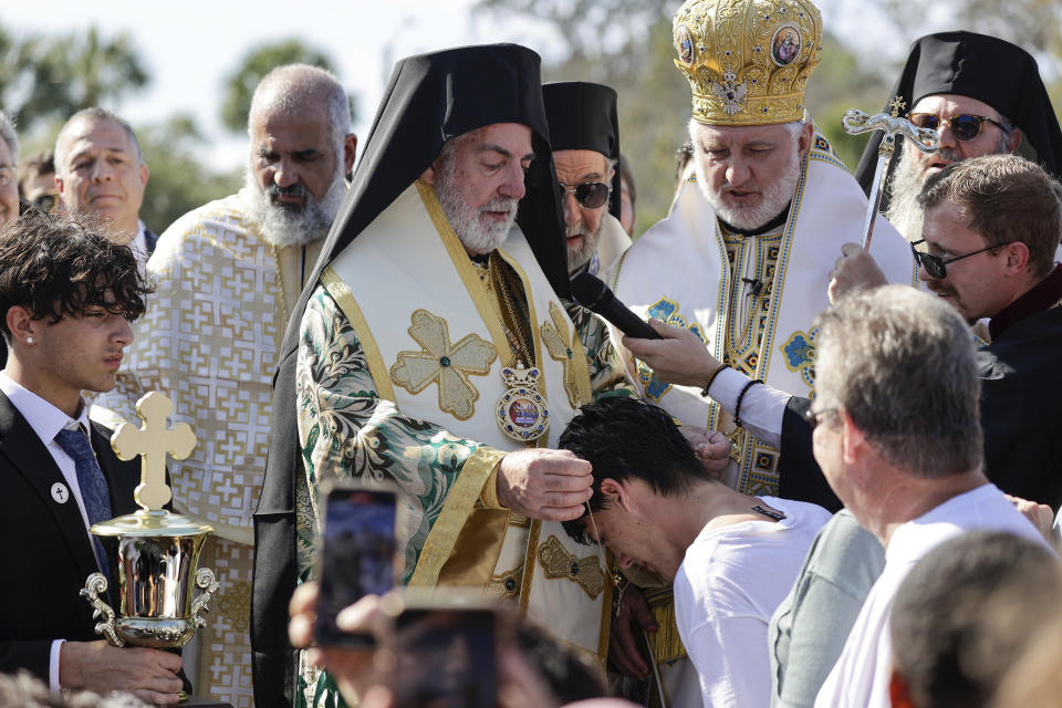 John Hittos, 16 celebrates after retrieving the cross during the 2024 Epiphany at Spring Bayou on Saturday, Jan. 6, 2024 in Tarpon Springs, Fla. (Luis Santana/Tampa Bay Times via AP)