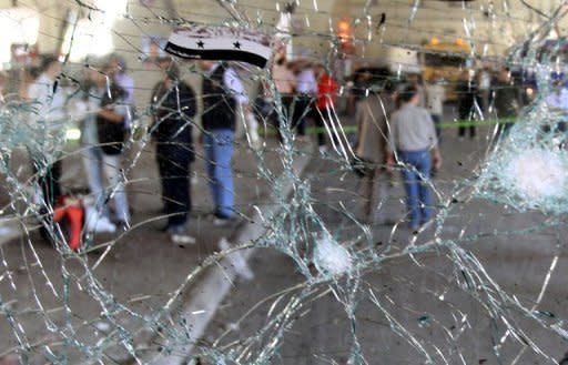 The damaged windshield of a minibus at the site of a blast in the central Midan district of Damascus. Tens of thousands of people protested across Syria as a deadly suicide bombing rocked the capital, killing 11 and fuelling growing scepticism over the prospects of a UN-backed peace plan