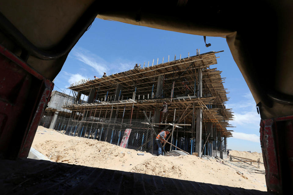 Palestinians work on a Qatari-funded construction project