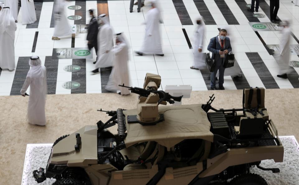 Visitors and officials pass by Sahm, a light tactical armoured vehicle assembled in UAE, during the opening day of the International Defence Exhibition & Conference, IDEX, in Abu Dhabi, United Arab Emirates, Sunday, Feb. 21, 2021. (AP Photo/Kamran Jebreili)