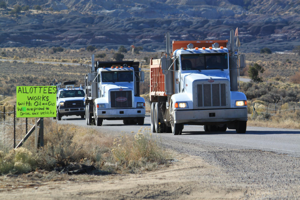 FILE - Oilfield trucks drive along the road that leads toward Chaco Culture National Historical Park in northwestern New Mexico on Monday, Nov. 22, 2021. The U.S. Interior Department's plan to withdraw hundreds of square miles in New Mexico from oil and gas production for the next 20 years is expected to result in only a few dozen wells not being drilled on federal land surrounding Chaco Culture National Historical Park, according to an environmental assessment. (AP Photo/Susan Montoya Bryan,File)