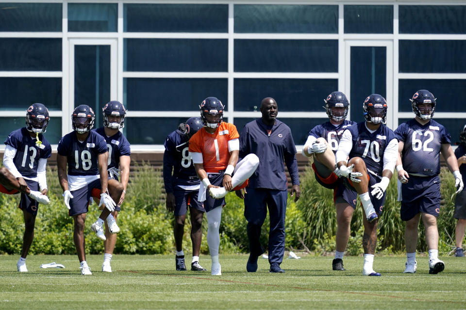 Chicago Bears quarterback Justin Fields (1) stretches on the field with teammates during NFL football practice in Lake Forest, Ill., Wednesday, June 9, 2021. (AP Photo/Nam Y. Huh)