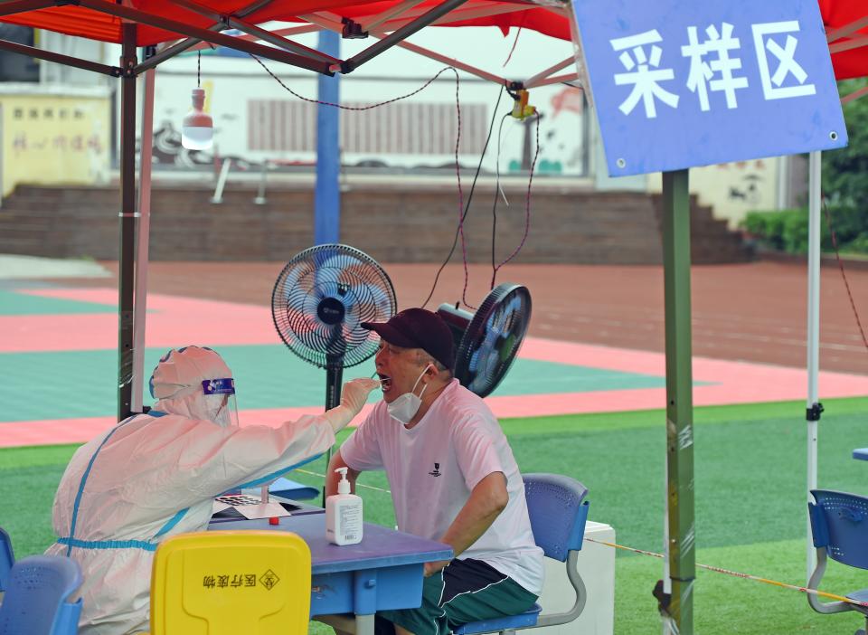 A medical worker takes a swab sample from a citizen for nucleic acid testing in Bengshan District of Bengbu City, east China's Anhui Province, July 16, 2022.  Bengbu in Anhui has started a new round of mass nucleic acid testing from Saturday to Sunday, as the city races against time to contain the latest resurgence of COVID-19 infections. (Photo by Zhou Mu/Xinhua via Getty Images)