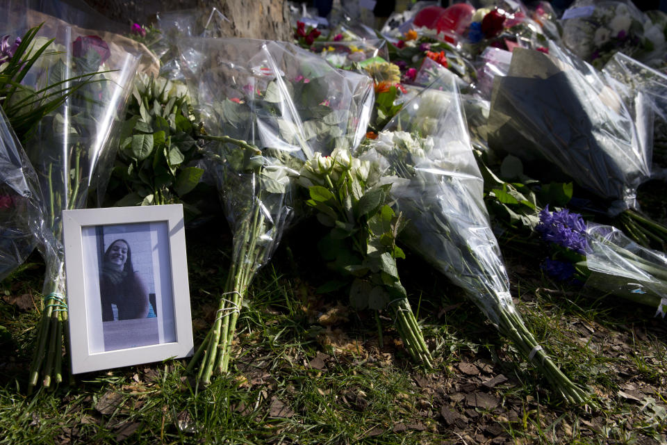 The picture of one of the three victims sits amidst flowers as mourners pay their respect at the site of a shooting incident in a tram in Utrecht, Netherlands, Tuesday, March 19, 2019. A gunman killed three people and wounded others on a tram in the central Dutch city of Utrecht Monday March 18, 2019. (AP Photo/Peter Dejong)
